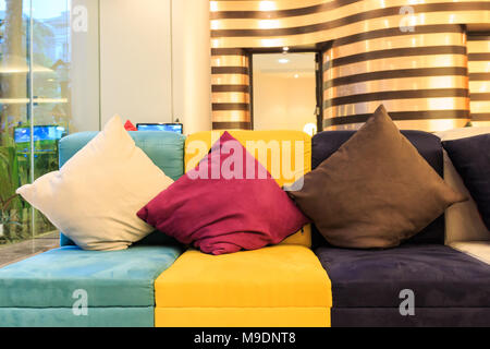 Oreillers décoratifs sur canapé en cuir coloré Banque D'Images