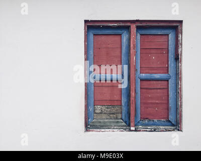 Fenêtre fermée, l'obturateur en bois vintage isolé sur mur blanc extérieur du bâtiment