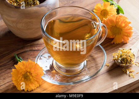 Une tasse de thé avec calendula calendula fleurs fraîches et sèches dans l'arrière-plan Banque D'Images