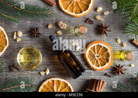 Sélection d'huiles essentielles avec chocolat et ingrédients : bouteilles d'huile essentielle, d'épinettes, de sapins, de résine d'encens, l'anis étoilé, la cannelle, cl Banque D'Images