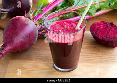 Le jus de betterave rouge dans un verre sur une table en bois, avec les betteraves fraîches dans l'arrière-plan Banque D'Images