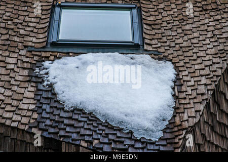 Assiette de la neige fond sous la place sur une fenêtre de toit en bois de décoration d'un immeuble moderne Banque D'Images