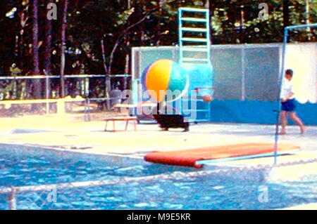 Prises d'une collection de diapositives qui ont été prises en vacances il y a des années. Classic cars alignés par le lac où les sports d'eau. Spectateurs alignés le long côté de la montagne qui a entouré le lac. Banque D'Images