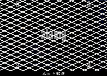 Fil de métal blanc en diagonale ou grille mesh, fond noir. Image en couleur Banque D'Images