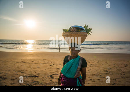 Une femme avec un panier en osier sur sa tête la vente de fruits sur la plage, de l'Inde, de Gokarna. Photo prise le 22 mars 2017. Banque D'Images