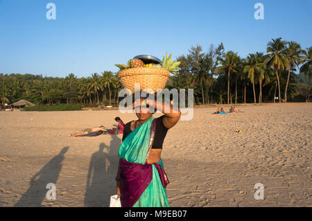 Une femme avec un panier en osier sur sa tête la vente de fruits sur la plage, de l'Inde, de Gokarna. Photo prise le 22 mars 2017. Banque D'Images