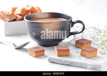 Caramel et biscuit sablé dessert bouchées sur du marbre et du cappuccino Banque D'Images