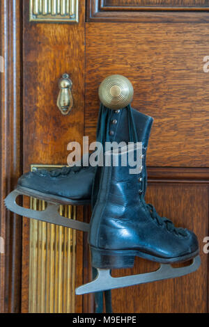 Quelques vieilles dames ou enfants des patins à glace accroché sur une poignée de porte dans une maison victorienne Banque D'Images