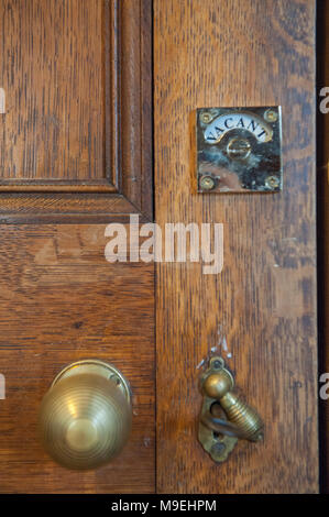 Postes vacants - portes de meubles laiton victorien sur une lourde porte en bois Banque D'Images
