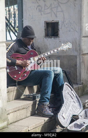 Un musicien ambulant effectue quelques jazz and blues au soleil sur les rives de la Tamise Banque D'Images