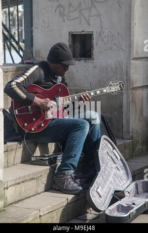 Un musicien ambulant effectue quelques jazz and blues au soleil sur les rives de la Tamise Banque D'Images