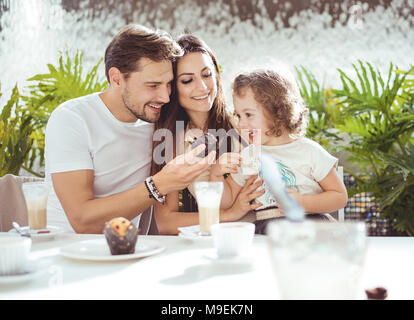 Cheerful parents de nourrir leur fille bien-aimée Banque D'Images