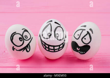 Les oeufs de Pâques avec des grimaces. Avec des oeufs face rire. Les œufs avec des émotions de surprise. Close up group d'oeufs avec le dessin des visages. Banque D'Images