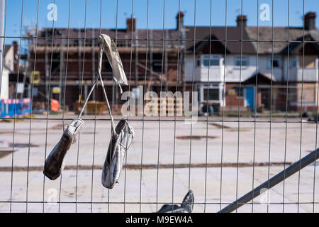 Une paire de chaussures de danse à gauche sur les garde-corps à l'emplacement d'où une école de danse. Nouveau traversier, Mesrseyside, UK, 25 mars 2018. année de d'une épouvantable explosion de gaz qui détruit une école et a causé des dommages aux bâtiments autour d'elle. Sur 12 mois et les réparations sont toujours en cours dans le village. © Christopher Middleton/Alamy Live News Banque D'Images