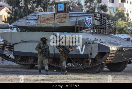 Des militants de Izz ad-Din al-Qassam, la branche militaire du mouvement islamiste palestinien Hamas, passons un modèle grandeur nature d'un Israélien Merkava réservoir pendant un exercice à grande échelle à l'extérieur de la ville de Gaza, bande de Gaza, le 25 mars 2018. Photo : Wissam Nassar/dpa Banque D'Images