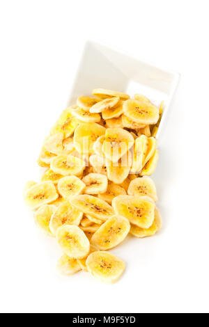 Tas de chips de banane séchée snack dans bol blanc sur fond blanc Banque D'Images