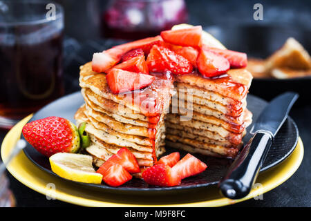 Pile de citron fraîchement préparé des crêpes aux graines de pavot avec des fraises fraîches et du sirop pour le petit déjeuner Banque D'Images