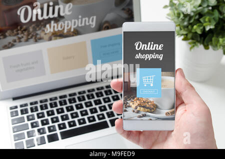 Magasinage en ligne concept sur smart phone et l'ordinateur portable. Main tenant le téléphone mobile. Banque D'Images