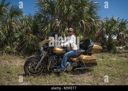 Jolie jeune fille avec de longs cheveux rouges portant des lunettes de soleil et chapeau assis sur une Harley Davidson Ultra Limited 2017 en Floride USA Banque D'Images