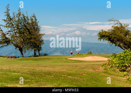 Un couple sur un parcours de golf de Maui, Hawaii, USA. Au-delà du golf est l'océan Pacifique et 5 788 pieds de haut Puu Kukui, Maui's premier volcan. Banque D'Images