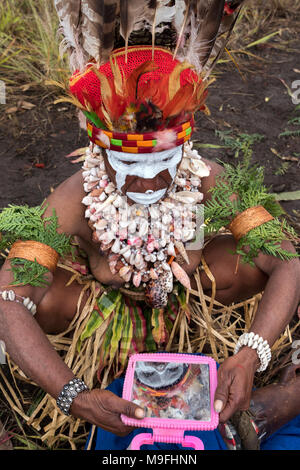 Une femme tribal vérifie son maquillage avant de procéder à la Mount Hagen Spectacle culturel dans les hautes terres de l'Ouest, la Papouasie-Nouvelle-Guinée. Banque D'Images