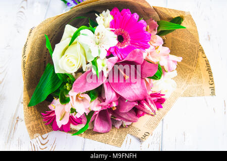 Un bouquet de fleurs d'un lys, gerbera, roses blanches et l'alstroemeria sur une table en bois blanc. Une maison de vacances, un cadeau Banque D'Images