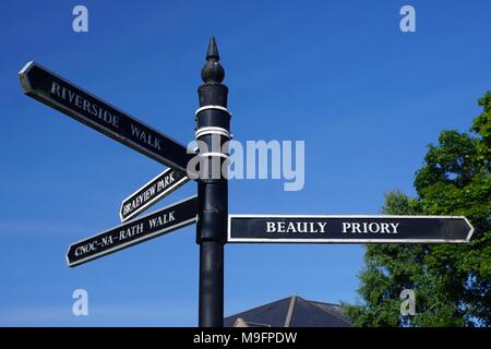 Beauly, comté d'Inverness, dans les Highlands écossais : des panneaux en anglais et le gaélique écossais contre un ciel bleu. Banque D'Images