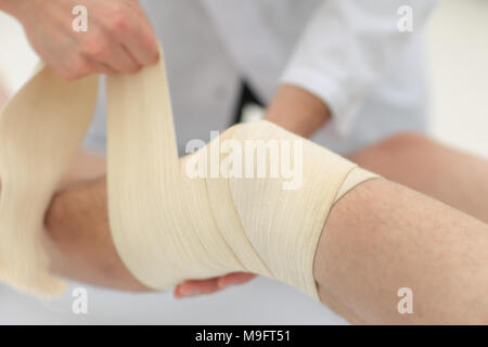 Libre. médecin des bandages une jambe du patient Banque D'Images