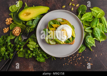 Petit-déjeuner avocat frais avec l'oeuf Benoît sandwich. Salade verte et de semences, l'alimentation végétarienne saine concept. Arrière-plan de l'alimentation. Vue de dessus, copiez l'espace. Banque D'Images