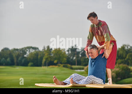 Massage thaï sur la pelouse du parc. Jeune homme massage faire à la haute vieil homme. Banque D'Images