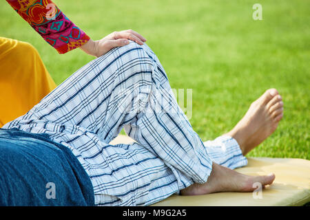 Jambes de pantalons, Close up. Couché sur le tapis de sol du parc. Banque D'Images