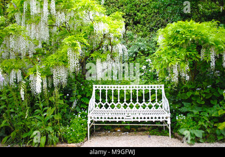 Un livre blanc sous le siège en fer forgé de style gothique wisteria blanc dans les motifs de Barnsley House . Banque D'Images