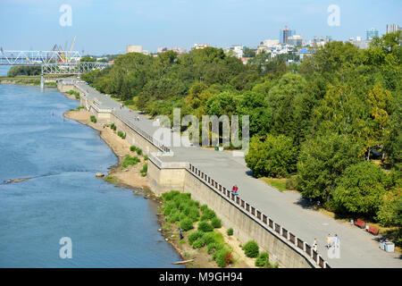 Novosibirsk, Russie - 24 août 2014 : les gens marcher sur le quai de la rivière Ob dans le parc 'Ville origine". Vieux pont de chemin de fer Transsibérien ( Banque D'Images