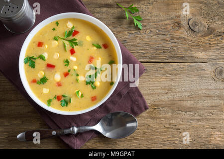 Chaudrée de maïs maison soupe dans un bol blanc. Soupe de maïs crémeux végétarien avec les verts et les légumes. Banque D'Images