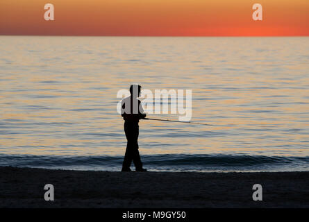 Un homme poissons dans les eaux calmes du golfe du Mexique sur Anna Maria Island, Floride. Banque D'Images