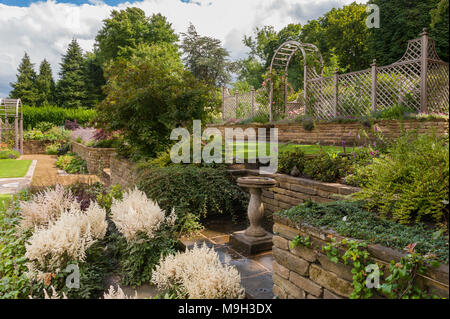 Cultures en terrasses, des plantes à fleurs sur la frontière, pelouse, murs en pierre, de treillis en bois arch & arbour - beautiful, conçu, aménagé, le jardin - Yorkshire, Angleterre. Banque D'Images