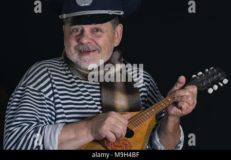 Portrait of smiling senior man in Striped Vest et couette avec mandoline Banque D'Images