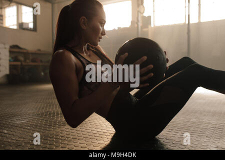 Remise en forme déterminée woman exercising with ball pilates à healthclub. Femme faisant entraînement avec l'aide de ballon. Banque D'Images
