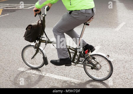 Rider d'un vélo pliant Brompton, Londres Uk Banque D'Images
