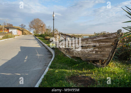 Épave bateau dans le côté de la route, avec de l'herbe à l'intérieur de , contre un ciel nuageux ciel bleu , Banque D'Images