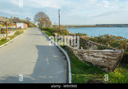 Épave bateau dans le côté de la route, avec de l'herbe à l'intérieur de , contre un ciel nuageux ciel bleu , Banque D'Images