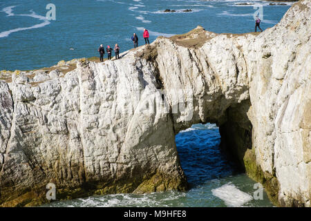 Groupe de randonneurs sur Bwa Gwyn ou arche blanche rocher naturel formé sur le long seacliffs Isle of Anglesey sentier côtier. Anglesey au nord du Pays de Galles UK Rhoscolyn Banque D'Images