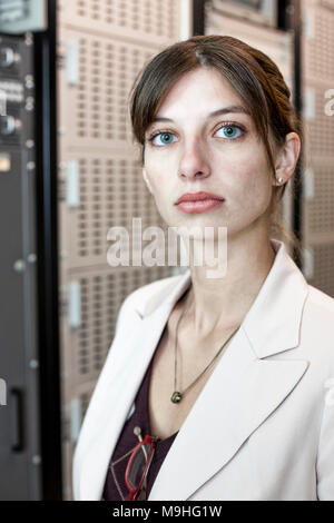 Portrait de femme technicien travaillant dans une grande salle de serveurs informatiques. Banque D'Images