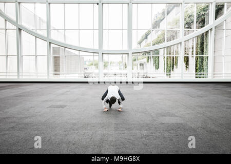 Businessman sitting dans un grand verre ouvert un passage couvert. Banque D'Images