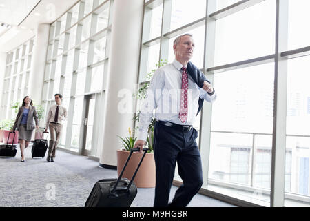 Businesspeople walking par un passage couvert sur la façon de prendre un avion. Banque D'Images