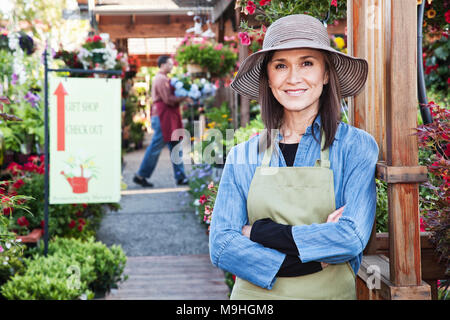 Caucasian woman propriétaire de centre de jardin pépinière avec un jeune employé. Banque D'Images