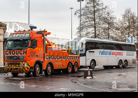 Transport lourd camion de remorquage remorquage d'un pool de National Express Coach Station de bus pré, Fairfax Street, Coventry, West Midlands, Royaume-Uni. Banque D'Images