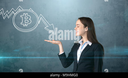 Successful business woman standing près de btc logo. Elle doit acheter ou vendre Bitcoin. Concept d'criptocurrency virtuel. Banque D'Images