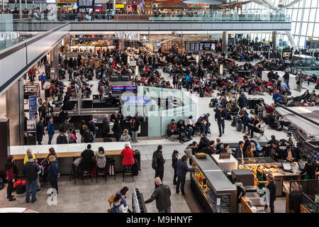 Les passagers qui attendent pour des départs à Heathrow Airport Terminal 5, où de nombreux vols ont été annulés en raison de la neige. BA service client, Starbucks. Banque D'Images