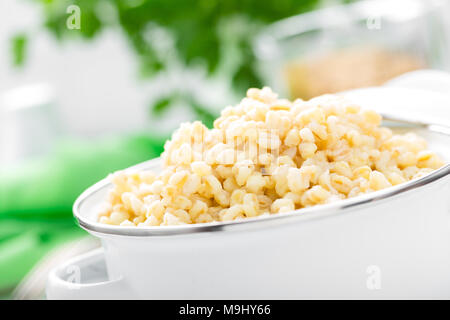 Boulgour. Boulgour bouilli céréale en pot sur la table de cuisine blanche. La nourriture végétarienne saine Banque D'Images